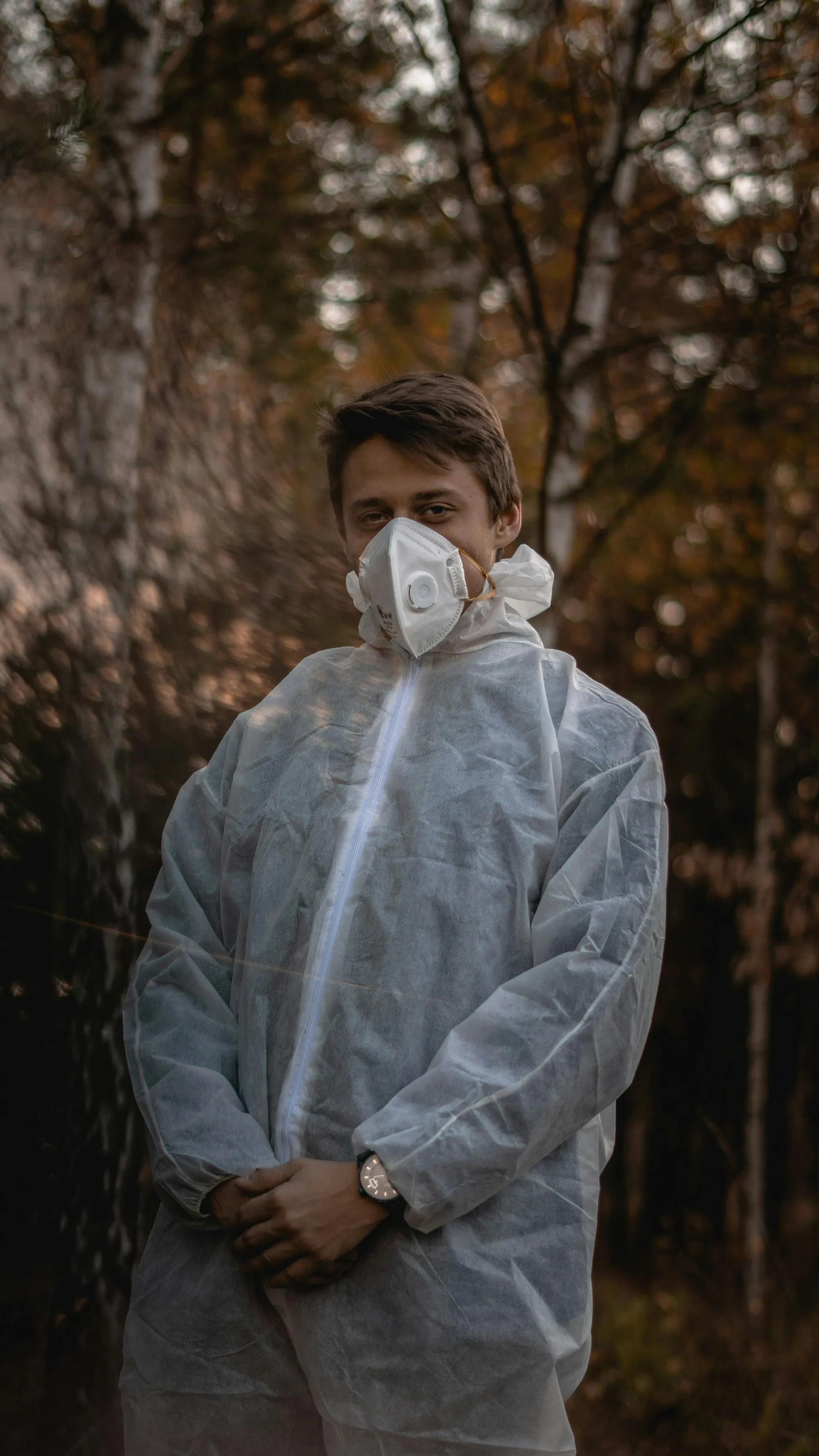 Worker in a white protective suit with a respirator mask