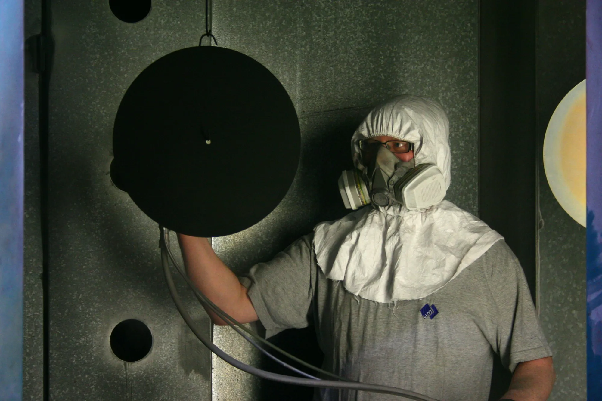 Abatement worker in a hooded suit and half-face respirator